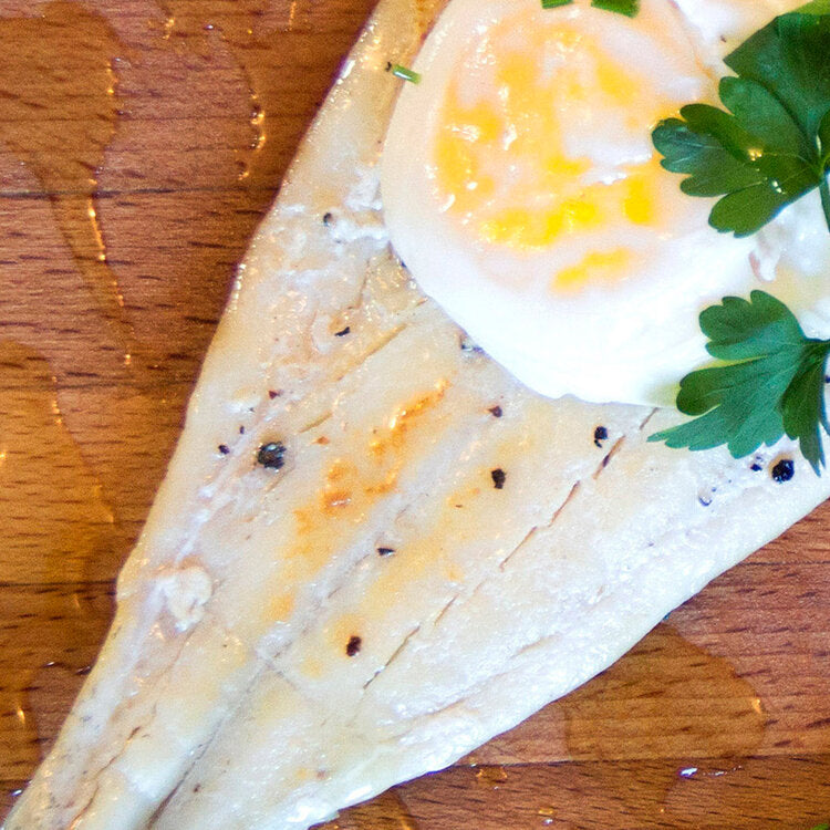 Several pieces of haddock placed on a tray with ice crystals, indicating freshness and readiness for cooking.